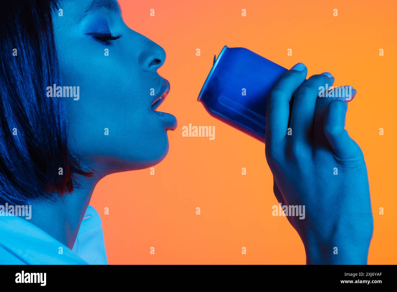 Fille afro-américaine boire une canette de soda Banque D'Images