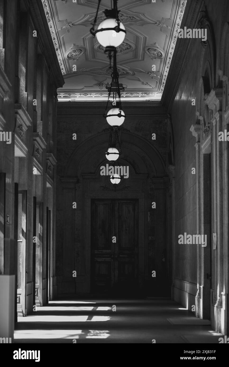 Une photo de couloir en noir et blanc avec des lumières suspendues au plafond Banque D'Images
