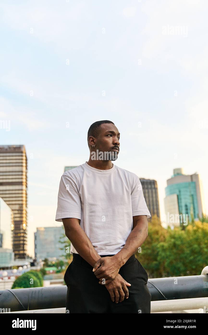 Photo verticale d'un jeune homme noir vêque de vêtements de rue en toute confiance en marchant à l'extérieur Banque D'Images