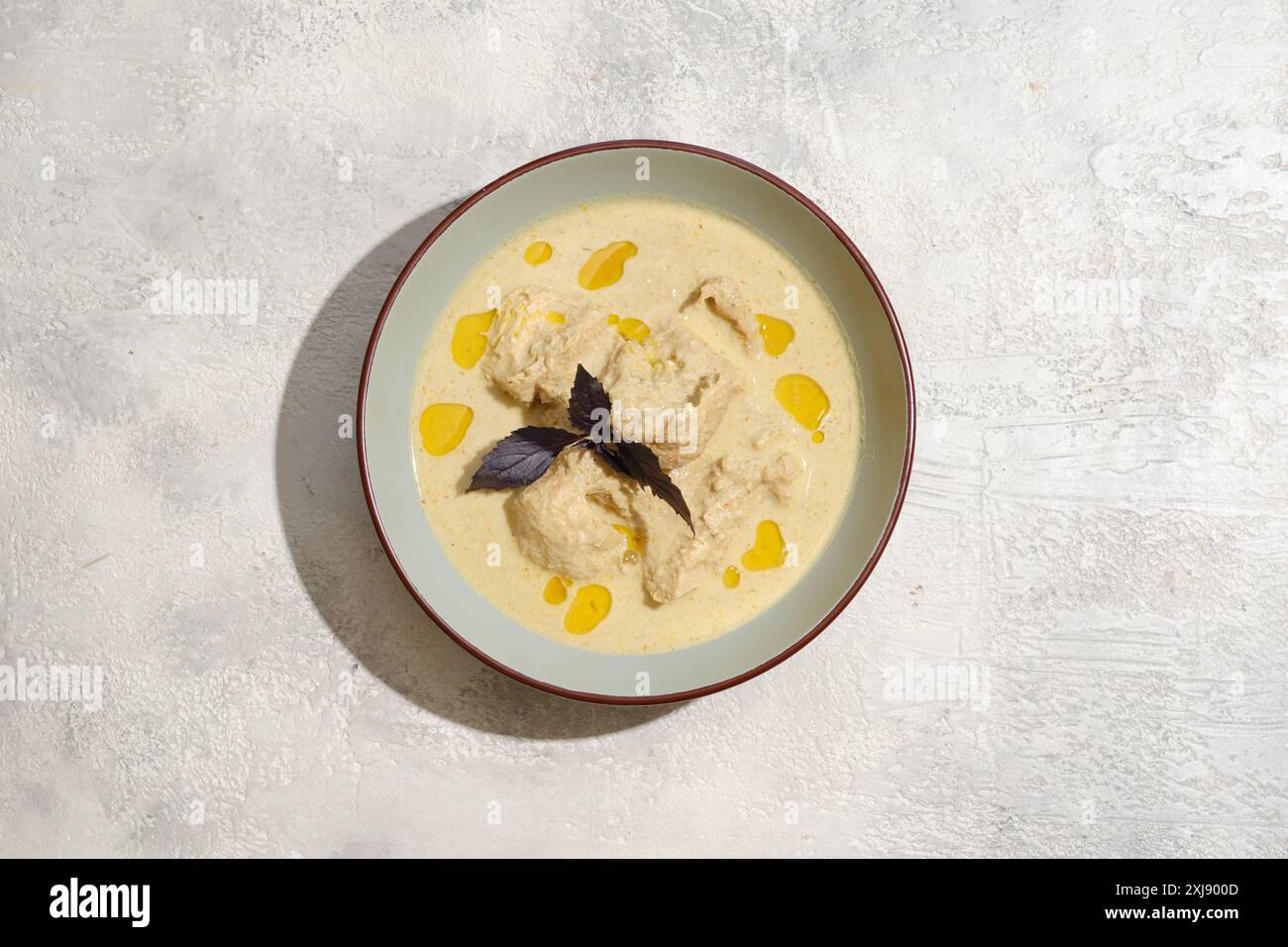 Vue aérienne de l'assiette avec des morceaux de poulet cuits dans la sauce aux noix Banque D'Images