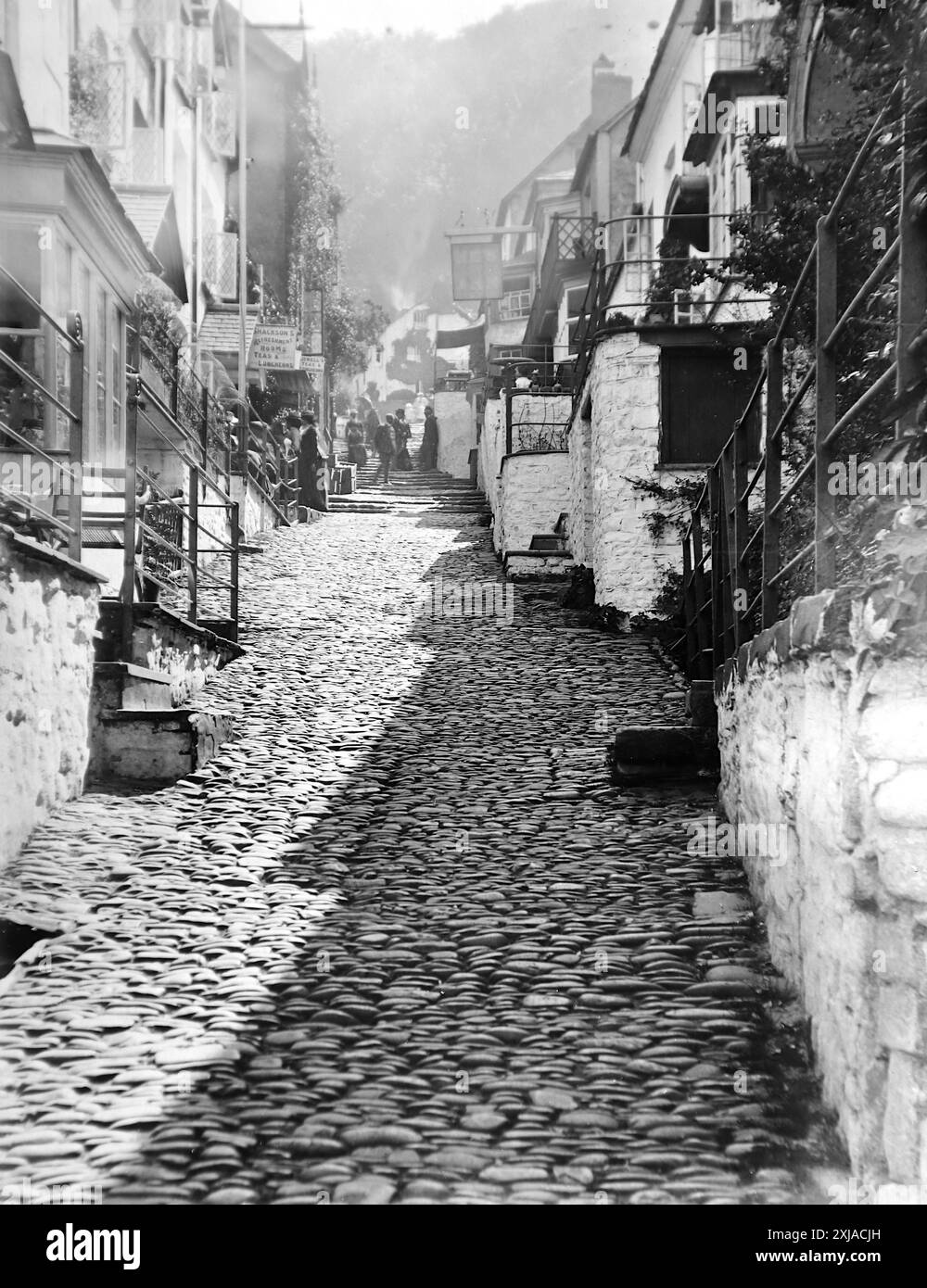 Shackson’s rafraîchissements, Jewell’s Tea Rooms et The New Inn, High Street (en haut de la colline), Clovelly, Devon. Cette photographie est tirée d'un original édouardien, vers 1910. L'original faisait partie d'un album de 150 photographies d'albumen, de qualité variable, dont beaucoup j'ai photographié. La collection comprenait des images en particulier de l'île de Man et du comté anglais du Devonshire. Des annotations ont été incluses dans l'album mais, malheureusement, il n'y avait pas de dates précises. Les photos originales étaient en moyenne 6x4 ½ pouces. Banque D'Images