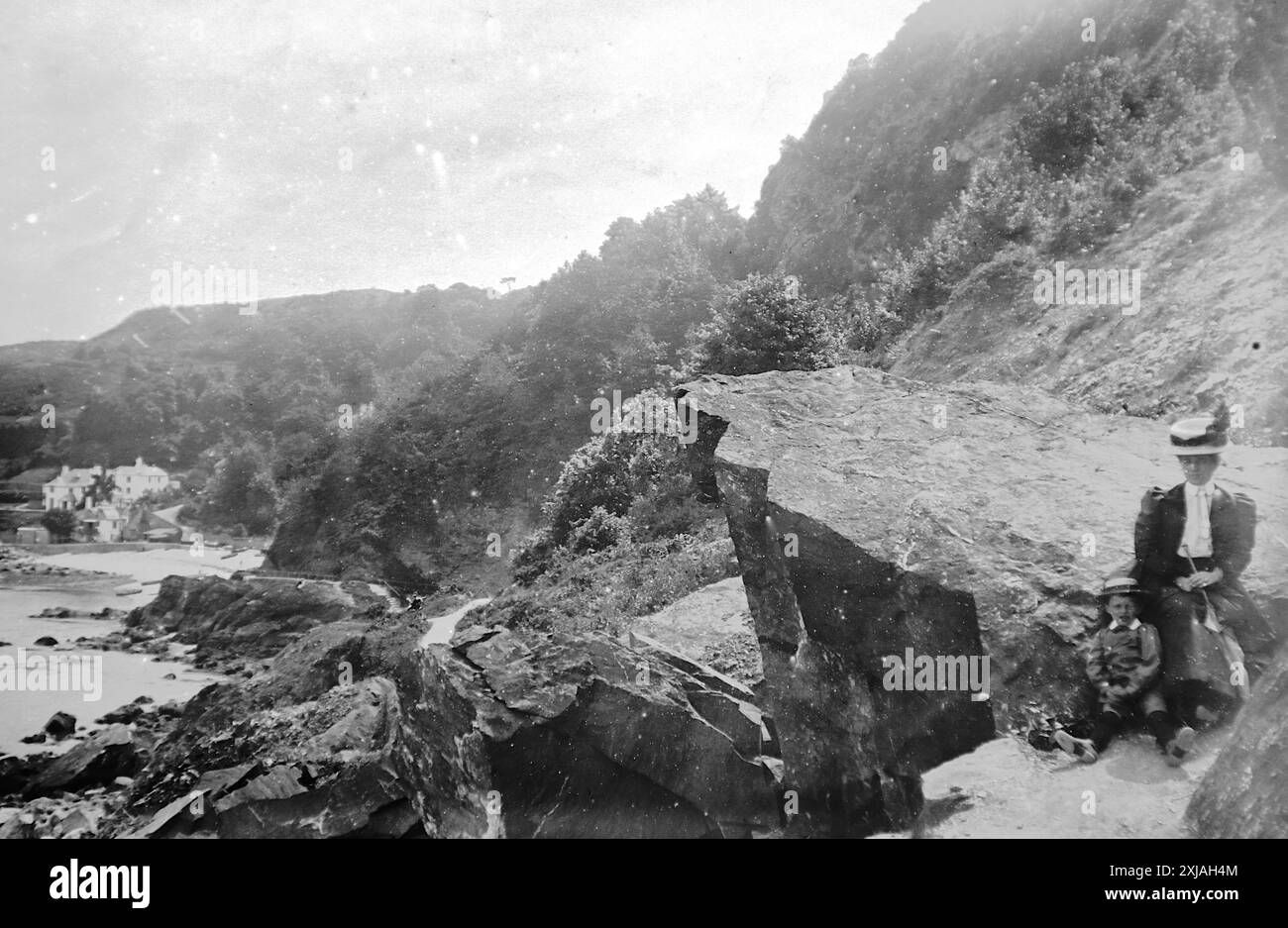 Une dame et un enfant sur un paysage rocheux près de Babbacombe, Torquay, Devon. Cette photographie est tirée d'un original édouardien, vers 1910. L'original faisait partie d'un album de 150 photographies d'albumen, de qualité variable, dont beaucoup j'ai photographié. La collection comprenait des images en particulier de l'île de Man et du comté anglais du Devonshire. Des annotations ont été incluses dans l'album mais, malheureusement, il n'y avait pas de dates précises. Les photos originales étaient en moyenne 6x4 ½ pouces. Banque D'Images