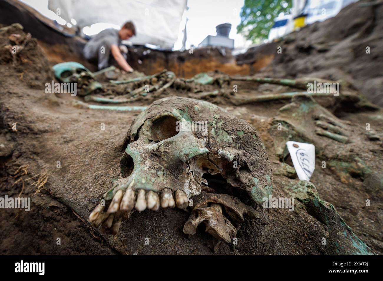 Nuremberg, Allemagne. 17 juillet 2024. Les restes humains d'une victime de la peste se trouvent dans le sol lors de fouilles archéologiques. Les squelettes de plusieurs centaines de victimes de la peste ont été découverts en février 2024 lors de travaux de construction sur le site d’une nouvelle maison de retraite. Selon l'archéologue de la ville de Nuremberg, c'est le plus grand cimetière de la peste en Allemagne - peut-être même en Europe. Crédit : Daniel Karmann/dpa/Alamy Live News Banque D'Images