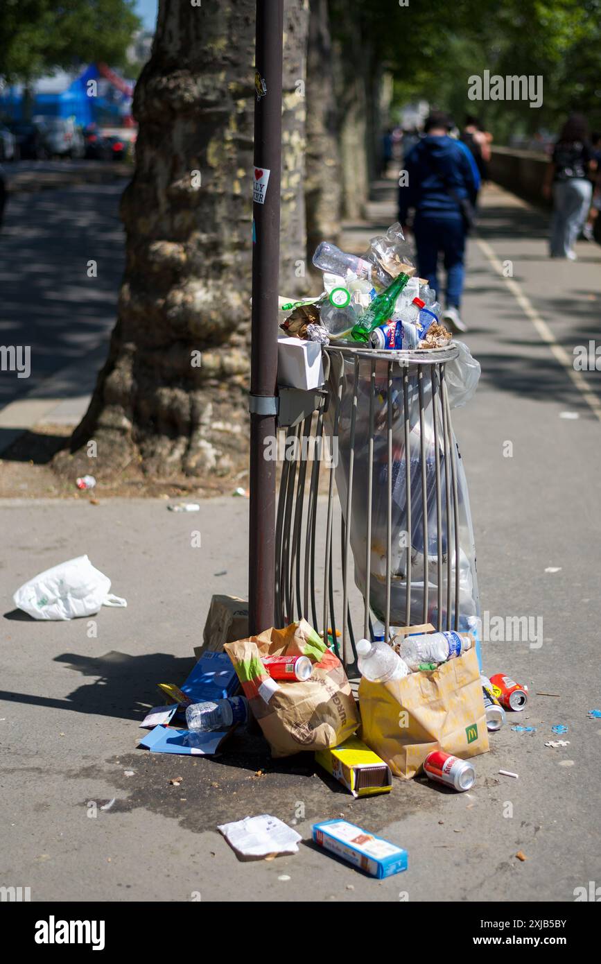 Paris, France. Une poubelle débordante sur un trottoir près de la Seine. Banque D'Images