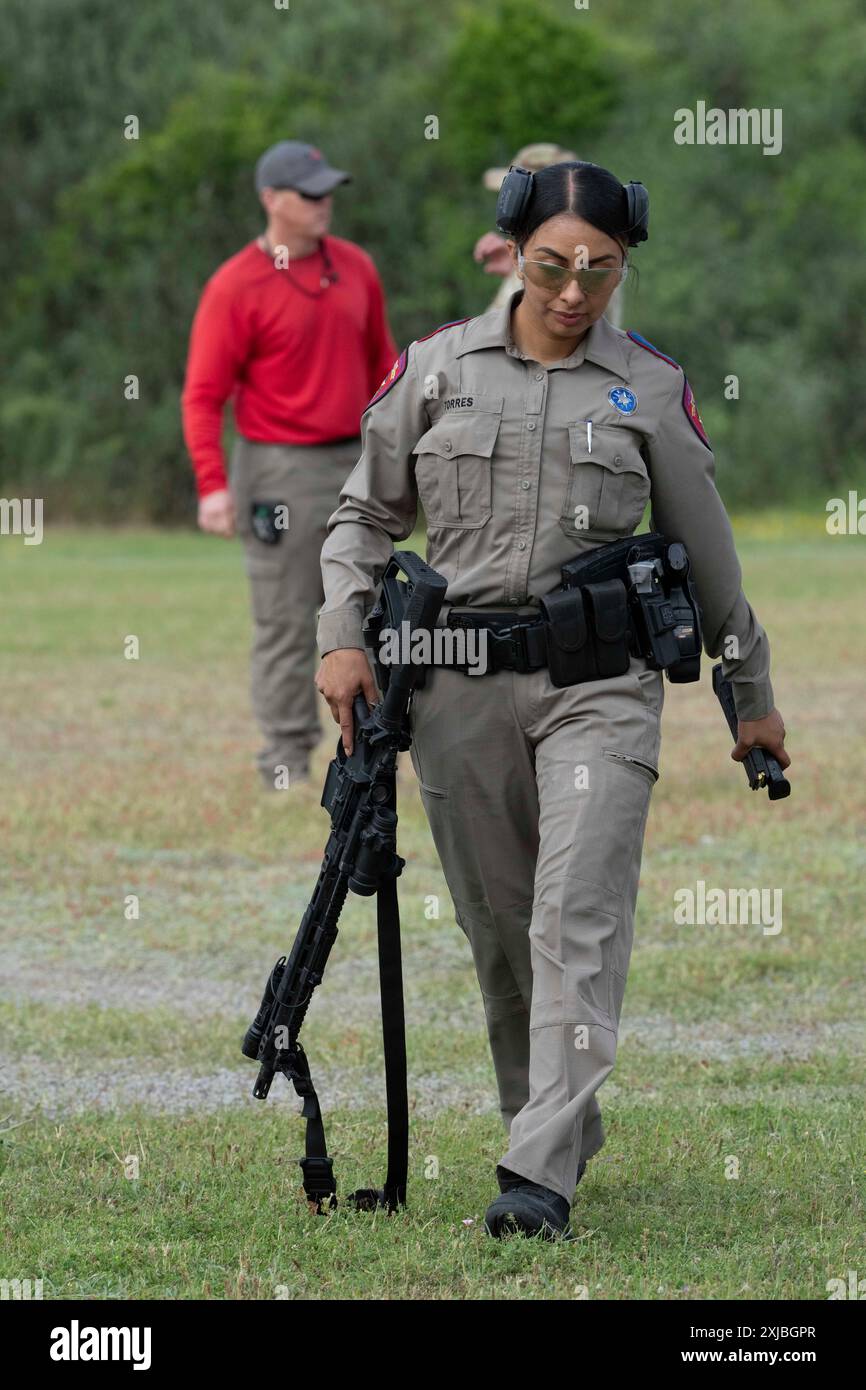 Florence Texas États-Unis, 23 avril 2024 : une femme de la Texas Department of public Safety State Trooper tient son arme entre les tirs dans le cadre de la 12e compétition annuelle Top Trooper. Les officiers du DPS ont concouru dans le conditionnement physique, le tir, l'endurance et les compétences de conduite. Au total, 120 soldats ont participé à la compétition et les deux vainqueurs ont reçu de nouveaux véhicules de patrouille. ©Bob Daemmrich Banque D'Images