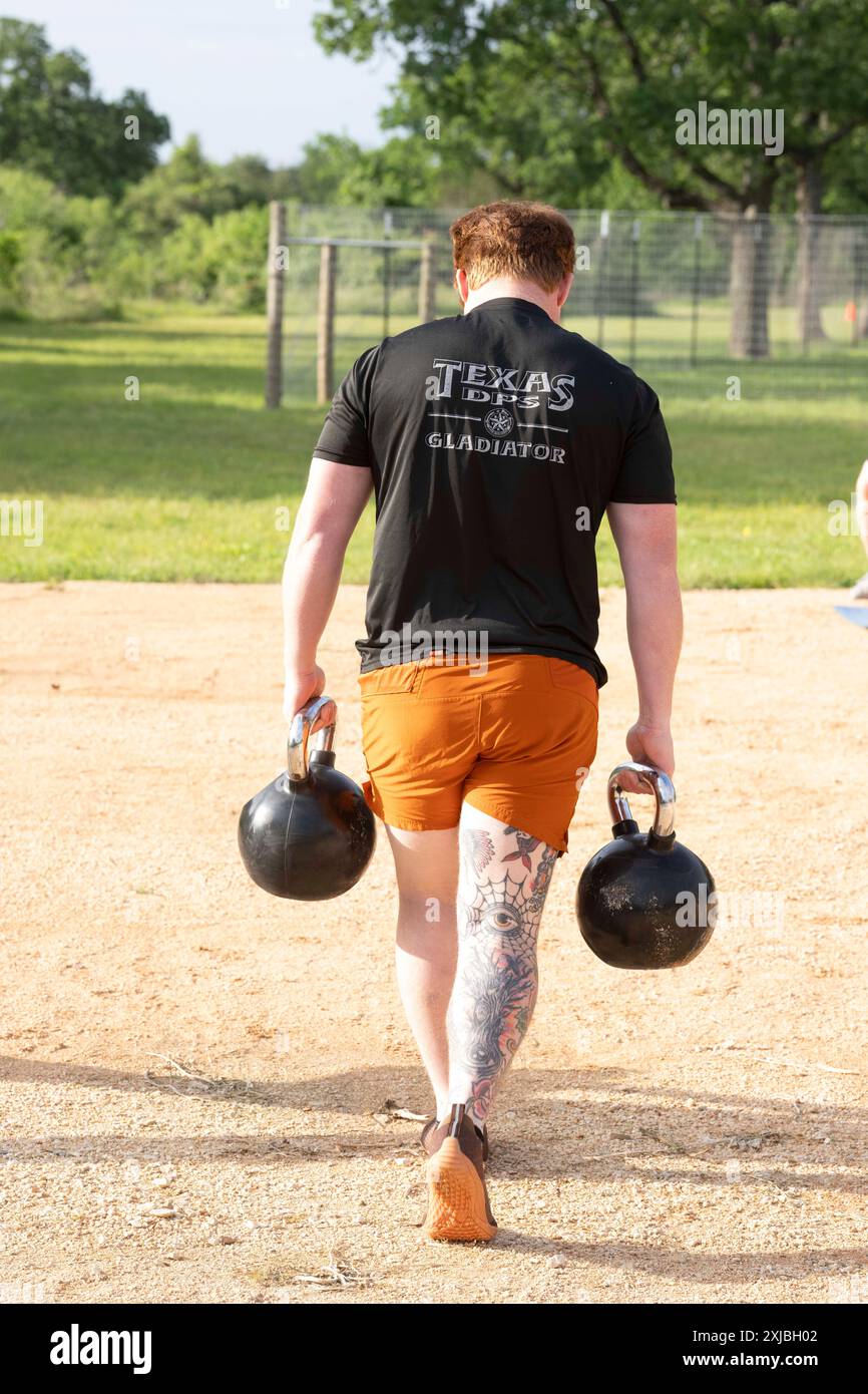 Florence Texas États-Unis, 23 avril 2024 : les troupes du Texas Department of public Safety soulèvent des kettlebells dans le cadre de la 12e compétition annuelle Top Trooper. Les officiers du DPS ont concouru dans le conditionnement physique, le tir, l'endurance et les compétences de conduite. Au total, 120 soldats ont participé à la compétition et les deux vainqueurs ont reçu de nouveaux véhicules de patrouille. ©Bob Daemmrich Banque D'Images