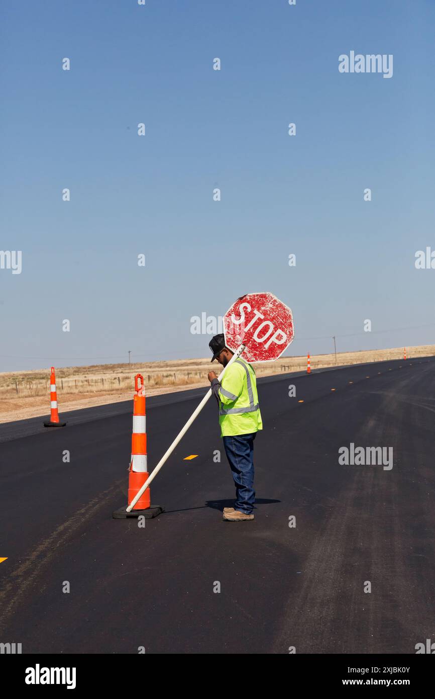 Contrôleur de la circulation, tenant le « panneau stop » communiquant, autoroute fraîchement pavée, axe central désigné, I-70, Strafford Wakeeney, Kanses, États-Unis, Banque D'Images