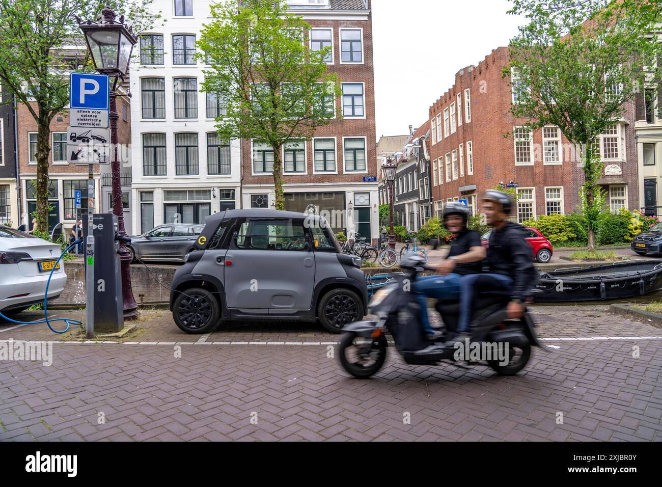 Miniauto in der Altstadt, Blauwburgwal Gracht, Innenstadt von Amsterdam, geparkt, Rocks Electric von Opel, E-Auto, Beliebt in der Stadt, weil er wenig Parkraum braucht, darf am 15 Jahren alter, mit Rollerführerschein, gefahren werden, Niederlande Amsterdam *** Mini voiture garée dans la vieille ville, canal Blauwburgwal, centre-ville d'Amsterdam, Rocks Electric par Opel, voiture électrique, populaire dans la ville parce qu'il a besoin de peu d'espace de stationnement, peut être conduit à l'âge de 15 ans, avec permis de conduire scooter, pays-Bas Amsterdam Banque D'Images