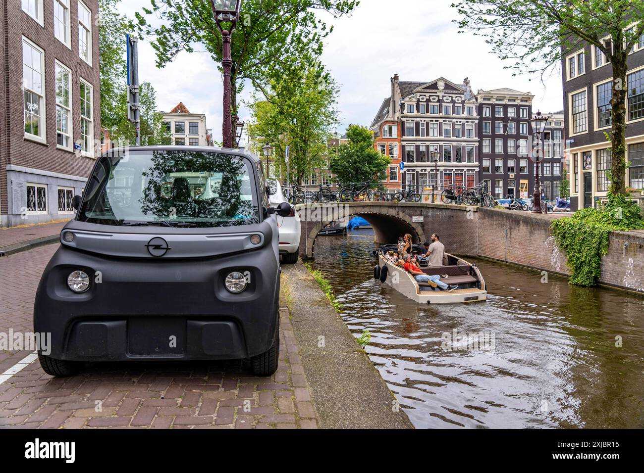 Miniauto in der Altstadt, Blauwburgwal Gracht, Innenstadt von Amsterdam, geparkt, Rocks Electric von Opel, E-Auto, Beliebt in der Stadt, weil er wenig Parkraum braucht, darf am 15 Jahren alter, mit Rollerführerschein, gefahren werden, Niederlande Amsterdam *** Mini voiture garée dans la vieille ville, canal Blauwburgwal, centre-ville d'Amsterdam, Rocks Electric par Opel, voiture électrique, populaire dans la ville parce qu'il a besoin de peu d'espace de stationnement, peut être conduit à l'âge de 15 ans, avec permis de conduire scooter, pays-Bas Amsterdam Banque D'Images