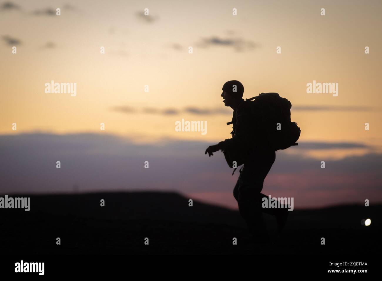 Un soldat de l'armée américaine de la 4e division d'infanterie classant les candidats pour l'Expert Infantryman, Soldier, et Field Medical badge, court devant les soldats lors de la dernière ligne droite de leur marche de 12 miles, signifiant la conclusion des tests EFMB à Fort Carson, Colorado, le 8 décembre 2023. La niveleuse a servi d'ancre pour ceux qui viennent à proximité derrière lui malgré des conditions difficiles, . (Photo de l'armée américaine par SPC. Joshua Zayas) Banque D'Images