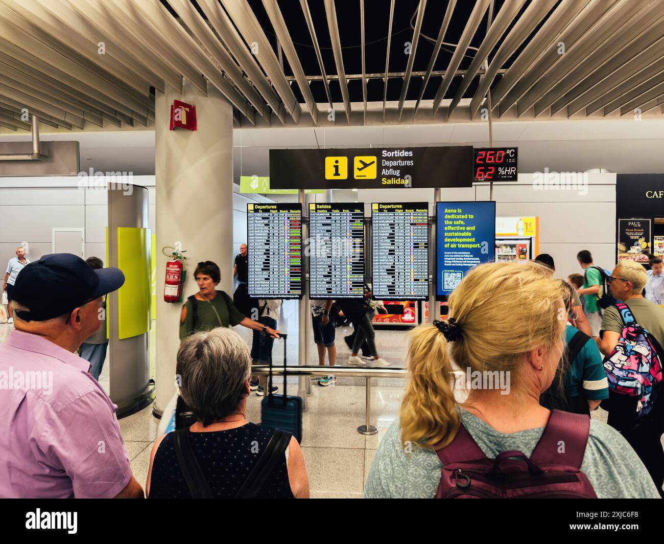 Palma, Espagne - 11 juillet 2024 : les voyageurs vérifient les informations de départ sur les écrans numériques de l'aéroport de PMI, avec un environnement de terminal très fréquenté avec divers passagers et panneaux Banque D'Images