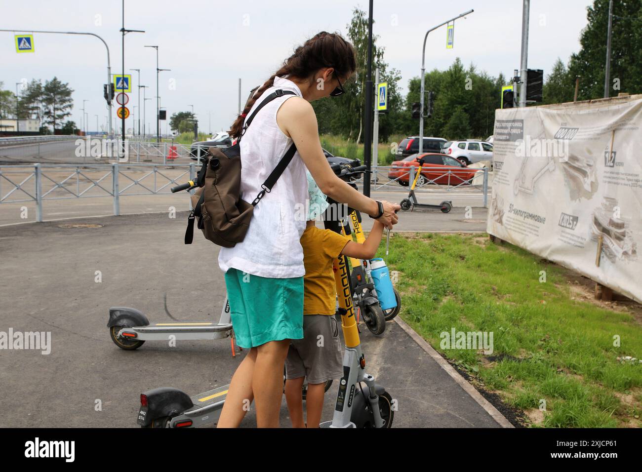 Cronstadt, Russie. 17 juillet 2024. Une femme avec un enfant monte sur un scooter électrique près du parc 'Île des forts', situé à Kronstadt, une ville en Russie, municipalité du centre-ville de tous Pétersbourg. Crédit : SOPA images Limited/Alamy Live News Banque D'Images