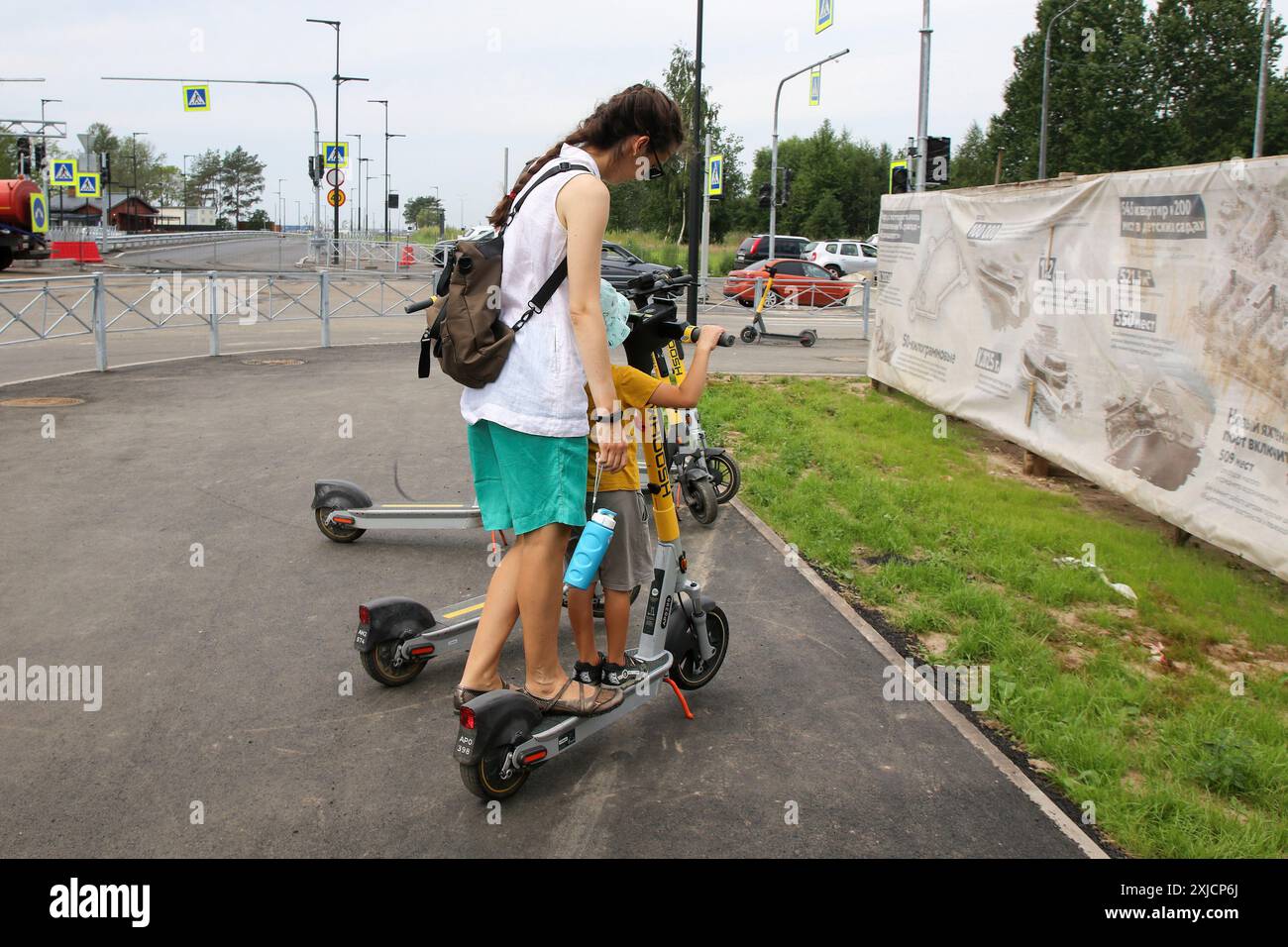 Cronstadt, Russie. 17 juillet 2024. Une femme avec un enfant monte sur un scooter électrique près du parc 'Île des forts', situé à Kronstadt, une ville en Russie, municipalité du centre-ville de tous Pétersbourg. Crédit : SOPA images Limited/Alamy Live News Banque D'Images