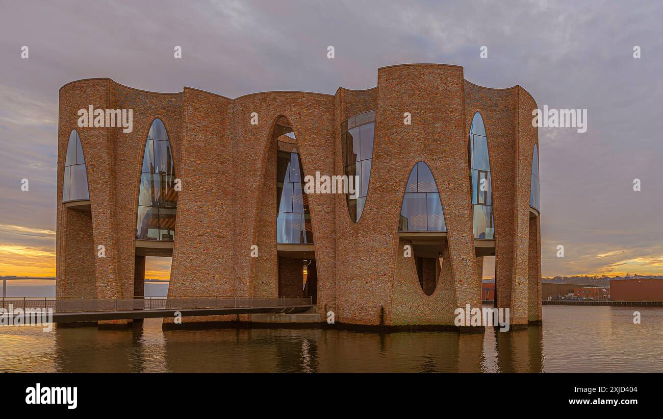 Bâtiment emblématique courbé dans l'entrée du port, reflets au lever du soleil, Vejle, Danemark, 15 novembre 2018 Banque D'Images