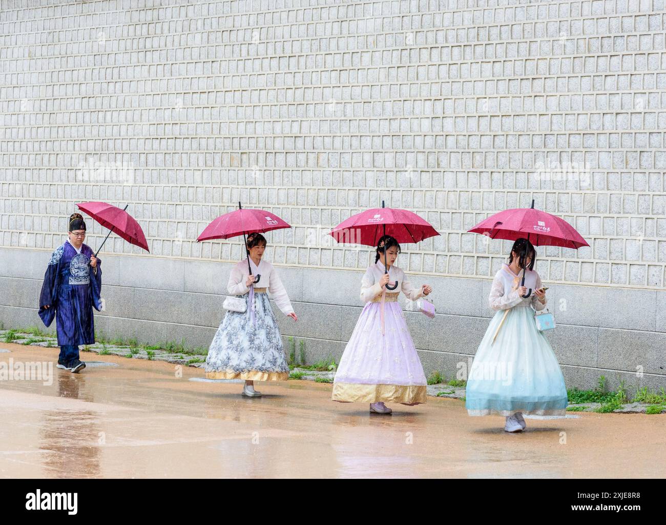 Séoul, Corée du Sud. 18 juillet 2024. Les touristes portant le hanbok traditionnel coréen tiennent des parapluies pour se protéger des fortes pluies lors d’une visite au palais de Gyeongbokgung, le palais royal de la dynastie Joseon (1392-1910). Des pluies torrentielles ont ravagé la région de Séoul et les régions adjacentes le 18 juillet, conduisant à l'évacuation des résidents en raison de l'enflement des cours d'eau et de la fermeture des autoroutes, d'un pont à Séoul et des services de métro à proximité. (Photo de Kim Jae-Hwan/SOPA images/Sipa USA) crédit : Sipa USA/Alamy Live News Banque D'Images