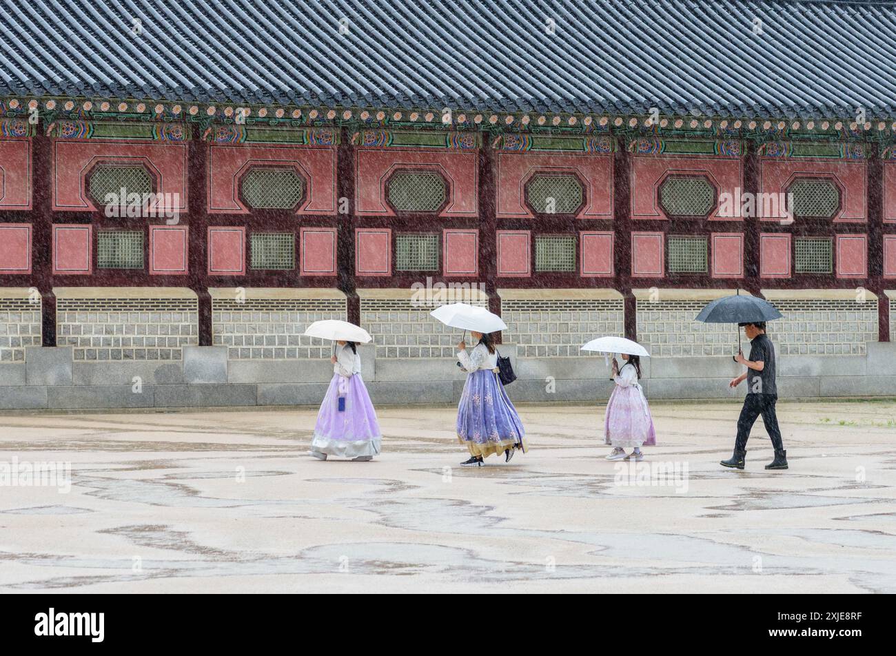 Séoul, Corée du Sud. 18 juillet 2024. Les touristes portant le hanbok traditionnel coréen tiennent des parapluies pour se protéger des fortes pluies lors d’une visite au palais de Gyeongbokgung, le palais royal de la dynastie Joseon (1392-1910). Des pluies torrentielles ont ravagé la région de Séoul et les régions adjacentes le 18 juillet, conduisant à l'évacuation des résidents en raison de l'enflement des cours d'eau et de la fermeture des autoroutes, d'un pont à Séoul et des services de métro à proximité. (Photo de Kim Jae-Hwan/SOPA images/Sipa USA) crédit : Sipa USA/Alamy Live News Banque D'Images
