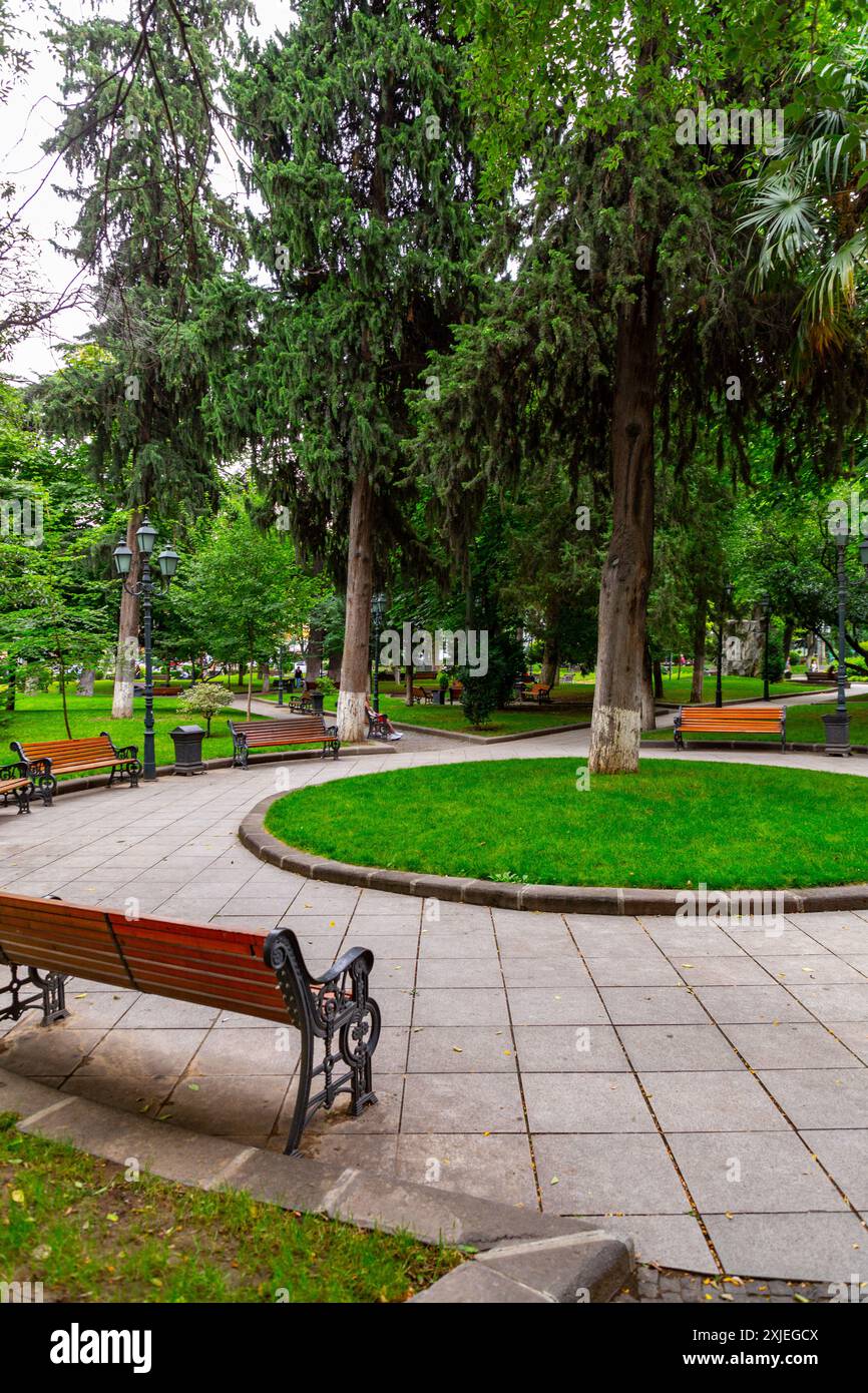 Tbilissi, Géorgie - 20 JUIN 2024 : arbres et bancs à l'intérieur du parc du 9 avril dans le centre de Tbilissi, Géorgie. Banque D'Images