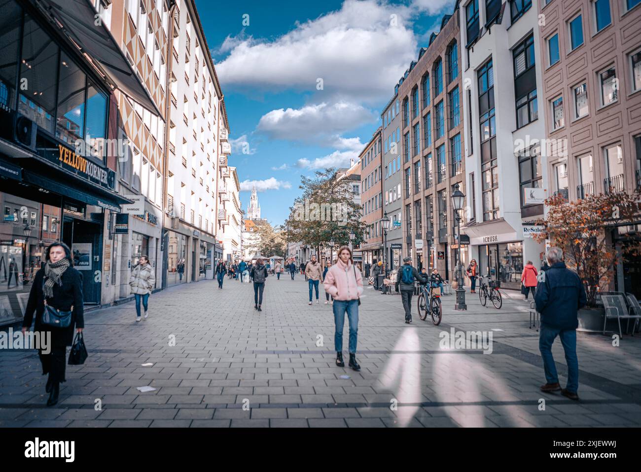 Munchen, Allemagne - 08 novembre 2023 : Une rue animée à Munchen, Allemagne, avec des piétons marchant devant des boutiques et des cafés sous un ciel bleu clair wi Banque D'Images