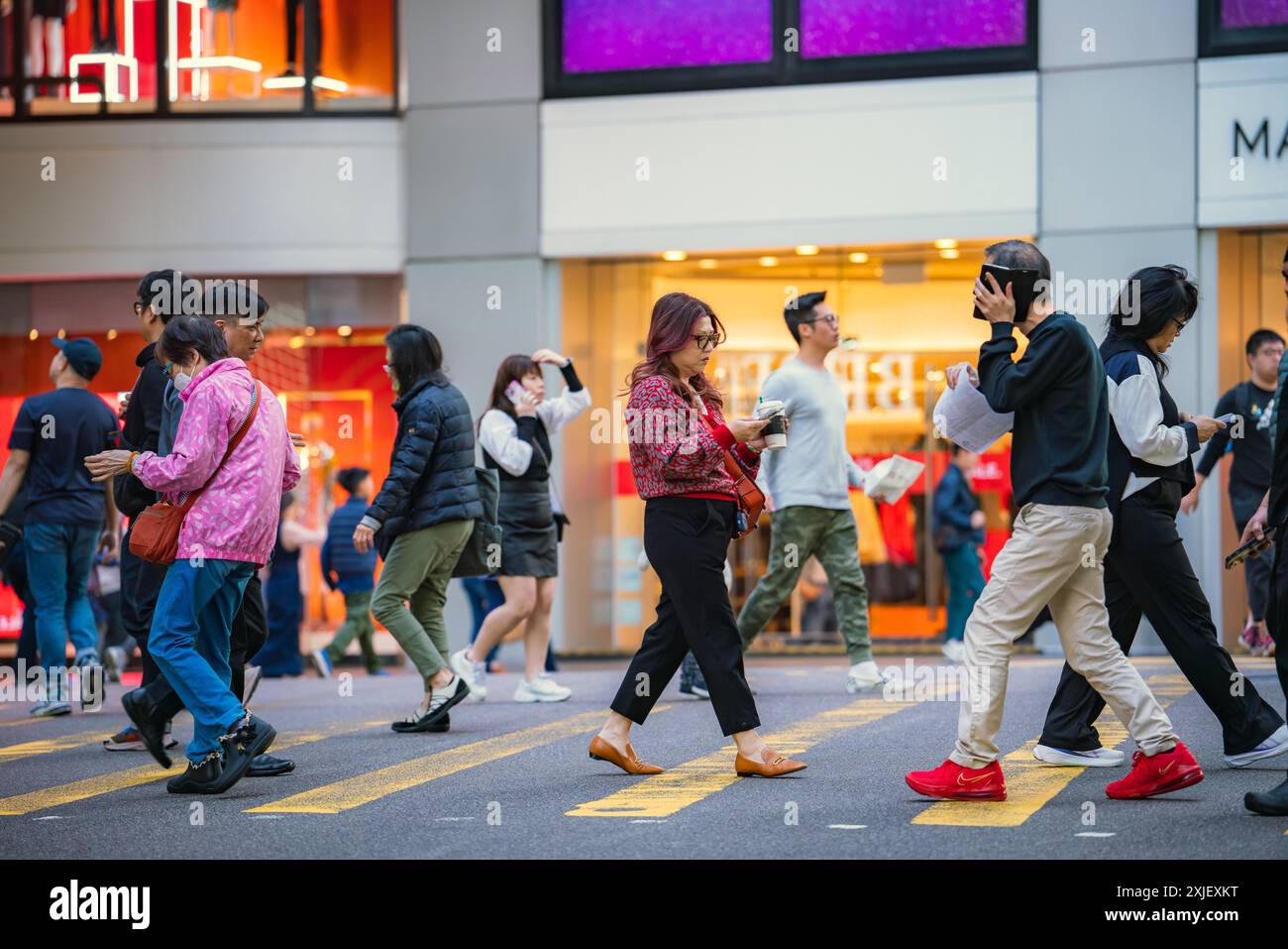 Hong Kong, Chine - 3 janvier 2024 : Un groupe de personnes traverse un passage pour piétons dans le centre de Hong Kong. Banque D'Images