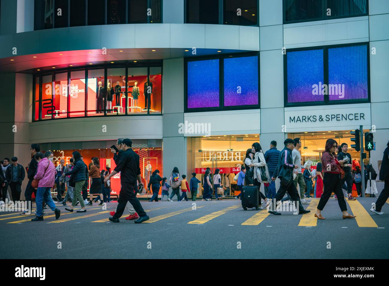 Hong Kong, Chine - 03 janvier 2024 : les gens traversent une rue devant un magasin dans le quartier Central de Hong Kong. Banque D'Images