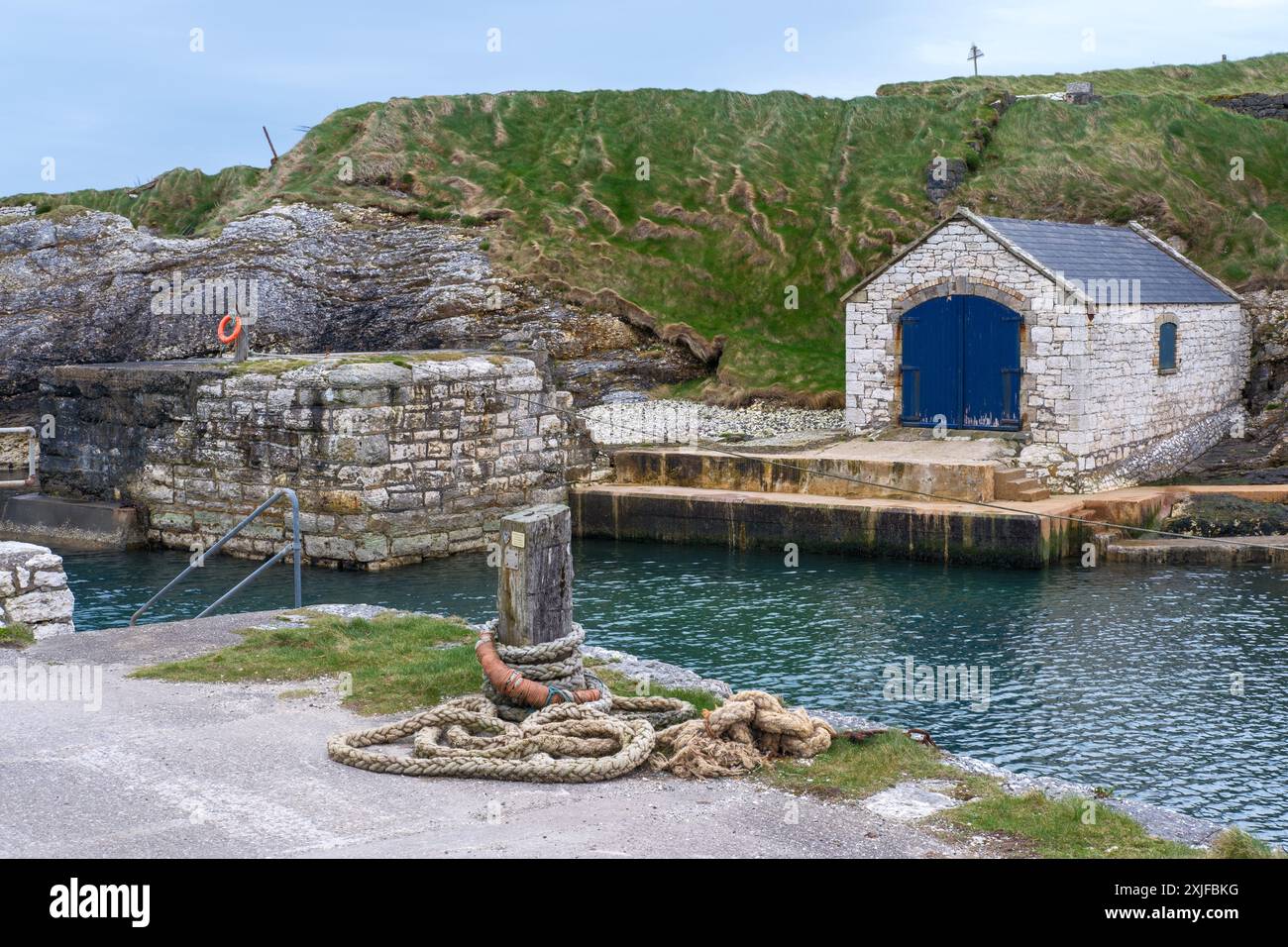 Hangar à bateaux en pierre à Ballintoy Harbour sur la Causeway Coast du nord d'Antrim en Irlande du Nord - l'un des emplacements de Game of Thrones Banque D'Images