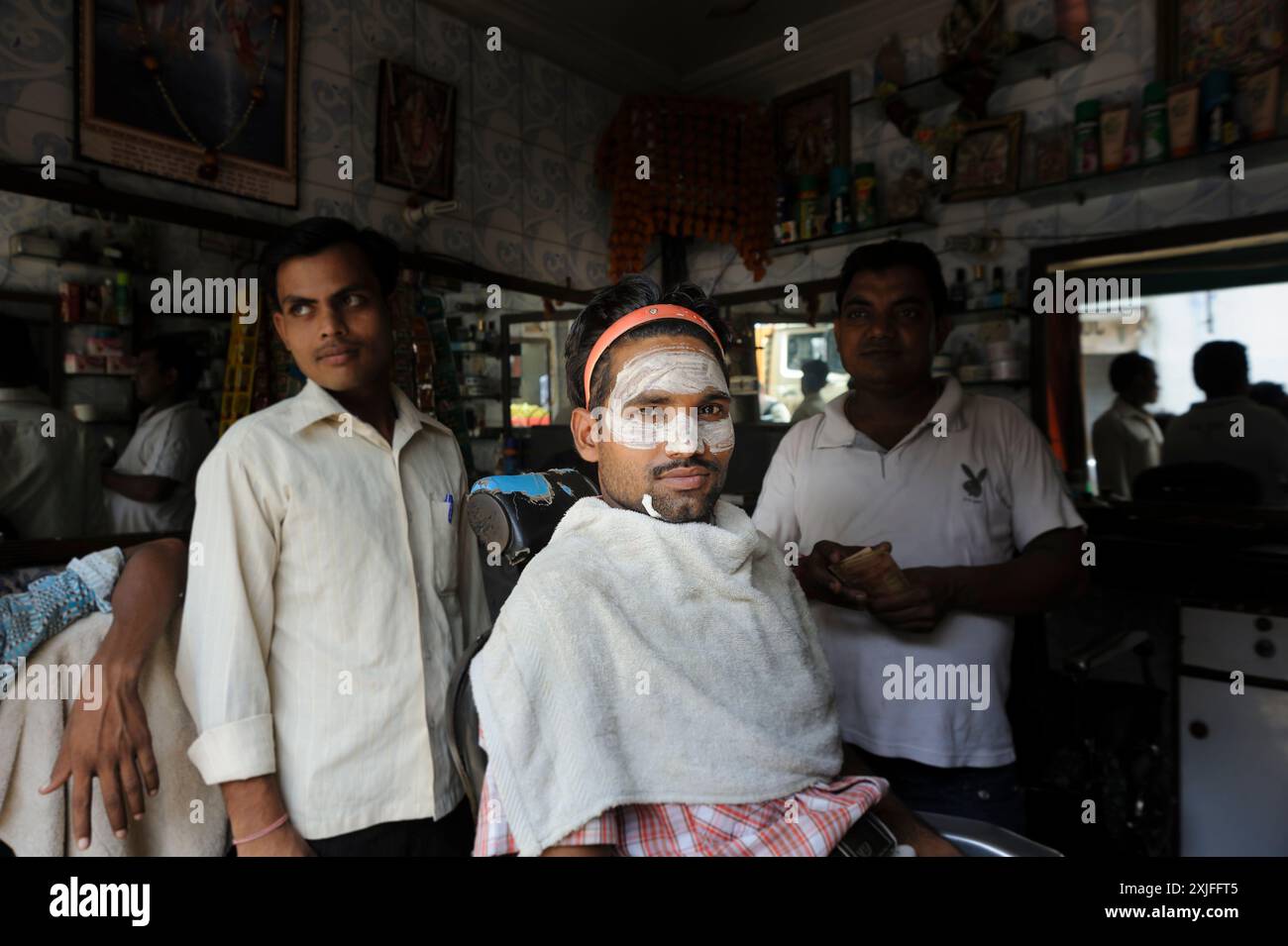 Client chez le coiffeur ou coiffeur avec un masque crème sur son visage, scène de la vie quotidienne à New Delhi, Inde Banque D'Images