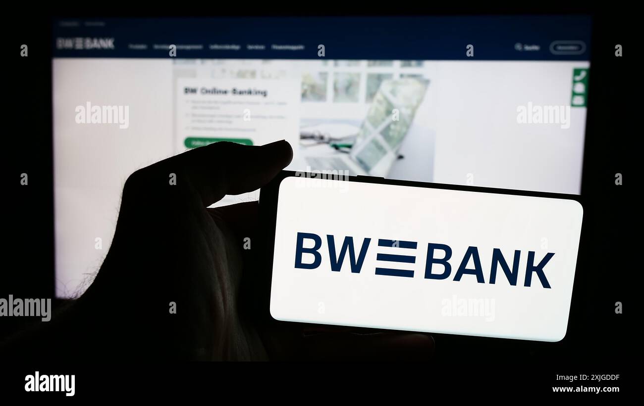 Personne tenant le téléphone portable avec le logo de la société allemande Baden-Württembergische Bank (BW-Bank) devant la page Web. Concentrez-vous sur l'affichage du téléphone. Banque D'Images