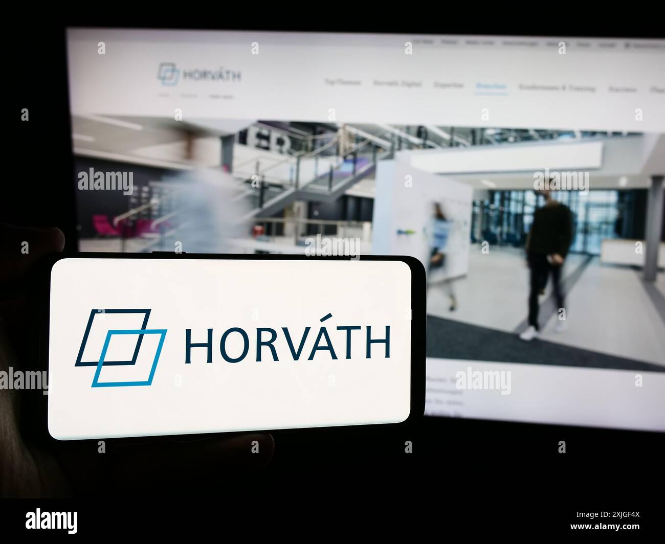 Personne tenant un smartphone avec le logo de la société allemande de conseil en gestion Horvath AG en face du site Web. Concentrez-vous sur l'affichage du téléphone. Banque D'Images
