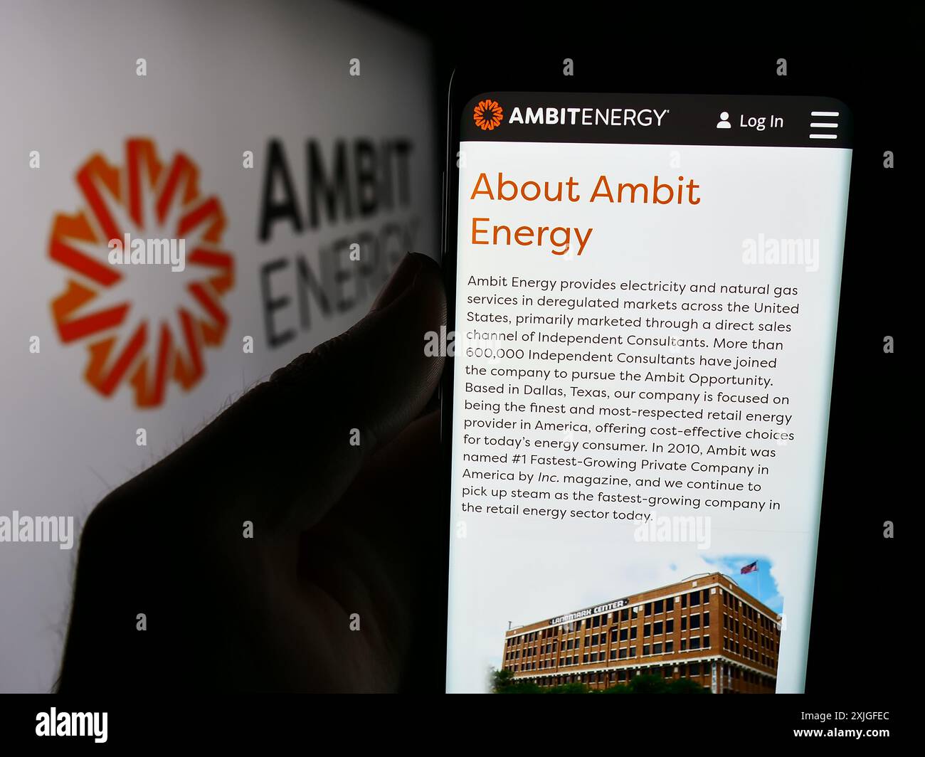 Personne tenant un smartphone avec la page Web de la société américaine de marketing multi-niveaux Ambit Energy devant le logo. Concentrez-vous sur le centre de l'écran du téléphone. Banque D'Images