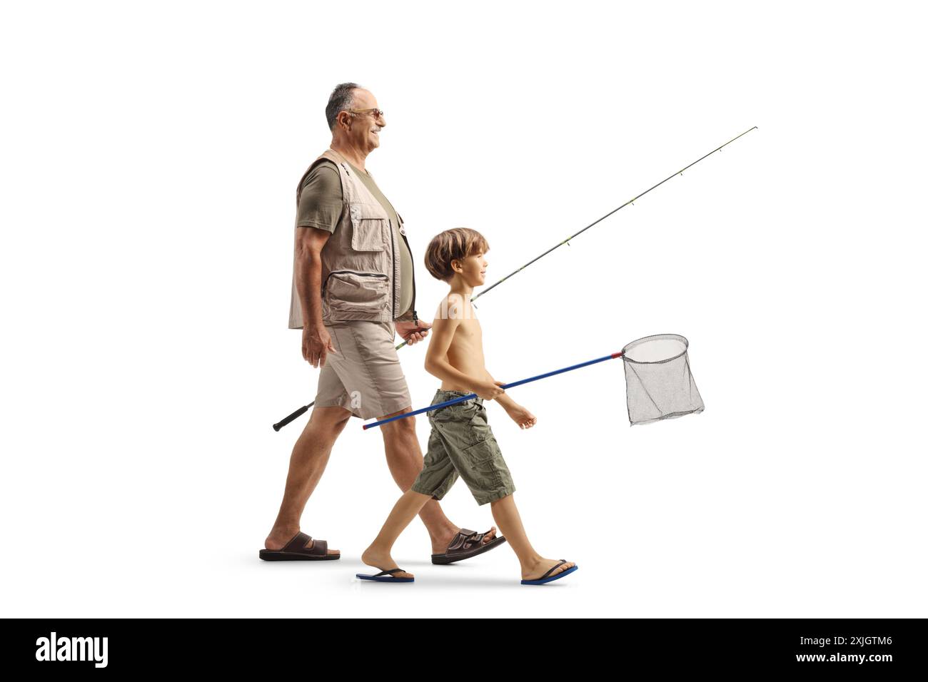 Plan de profil pleine longueur d'un homme mature et d'un garçon marchant avec une canne à pêche et un filet isolé sur fond blanc Banque D'Images