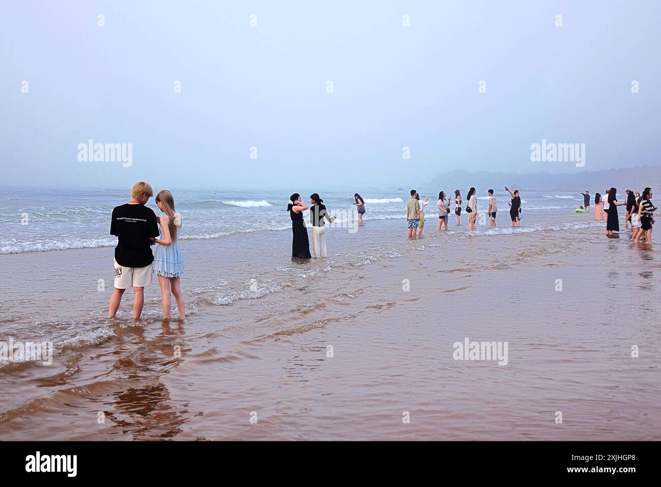 QINGDAO, CHINE - 19 JUILLET 2024 - les touristes viennent à la plage dorée dans la nouvelle région de la côte ouest pour regarder le lever du soleil sur la mer à Qingdao, Shandong Banque D'Images