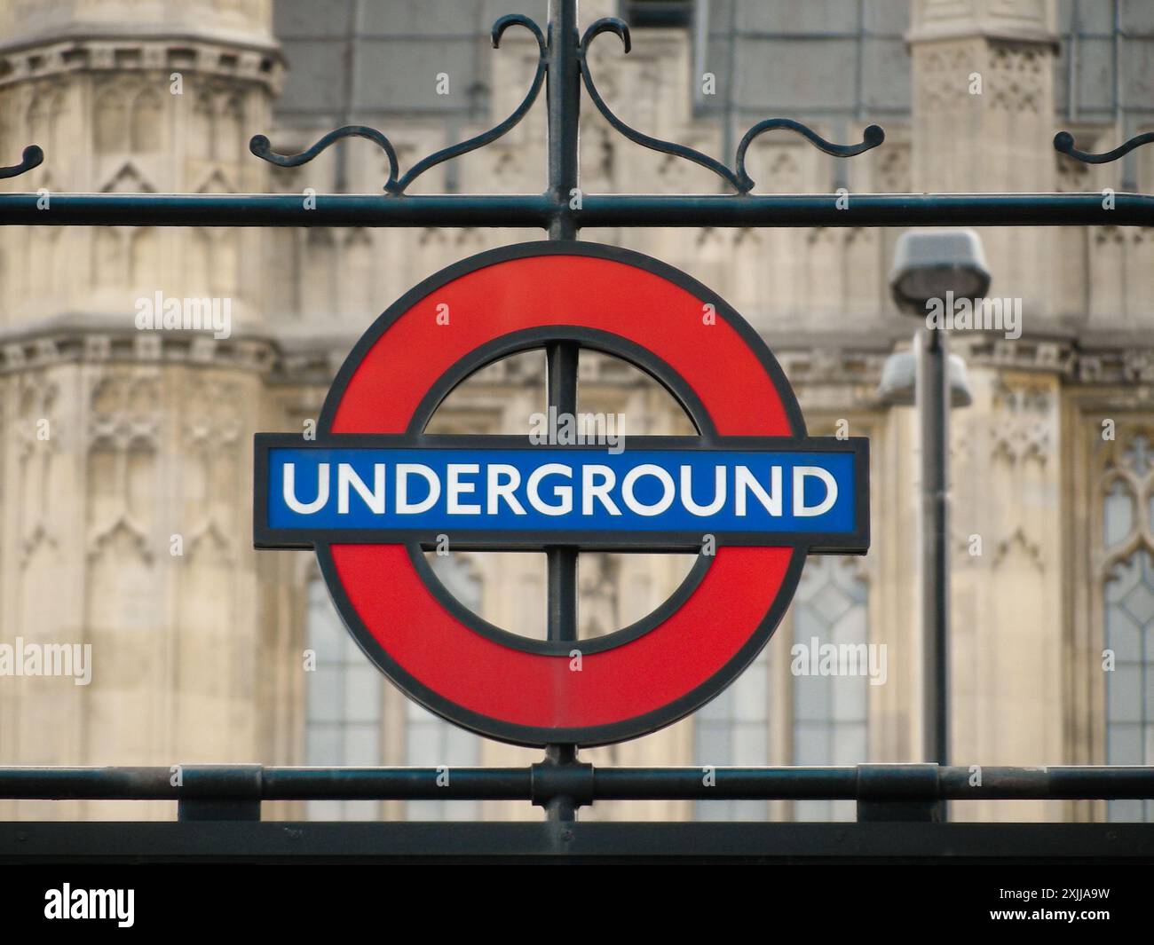 Panneau London Underground. Logo près d'une entrée de la station de métro Westminster. Palais de Westminster en arrière-plan. Banque D'Images