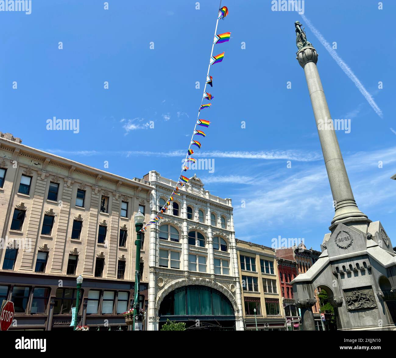 Monument avec guirlande de drapeau de fierté et bâtiments historiques à Troy, NY Banque D'Images