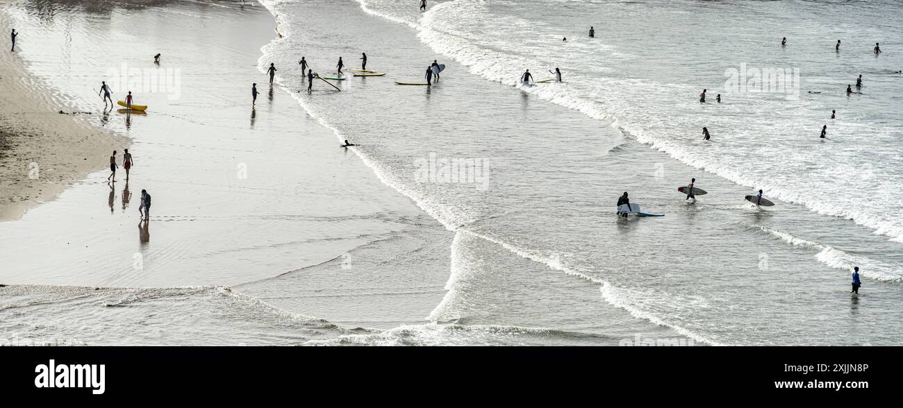 Les gens avec des planches de surf s'amusant sur une plage, Maroc Banque D'Images