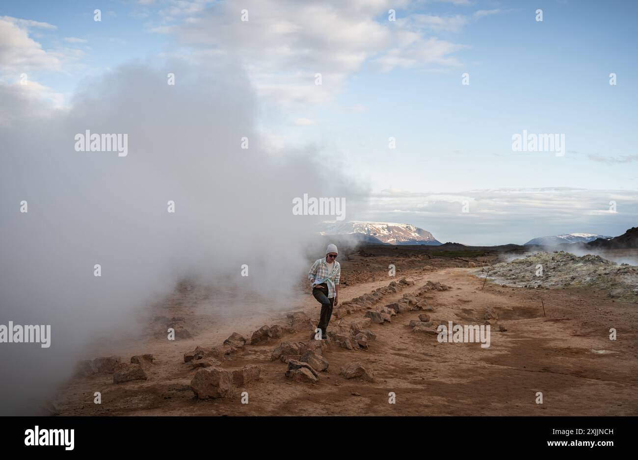 Femme touriste marche sur le gravier orange dans la zone géothermique de Myvatn Banque D'Images