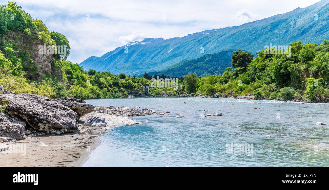 Une vue vers l'est sur la rivière Vjosa vers une passerelle à Kelcyre, Albanie en été Banque D'Images