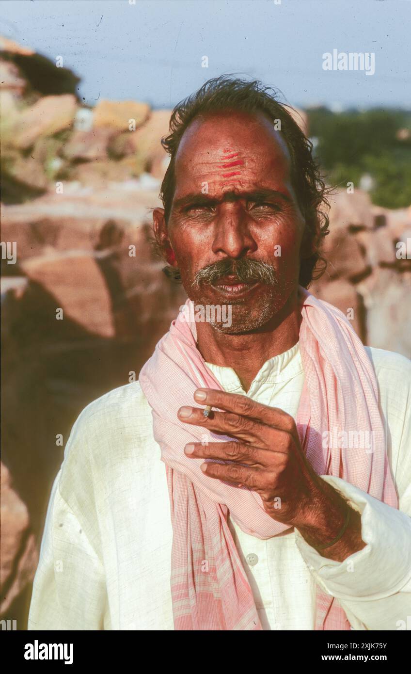 Jaisalmer, Inde - 25 mai 2008 : Portrait d'un vieil homme indien mature dans des vêtements locaux avec cigarette à la main. Banque D'Images