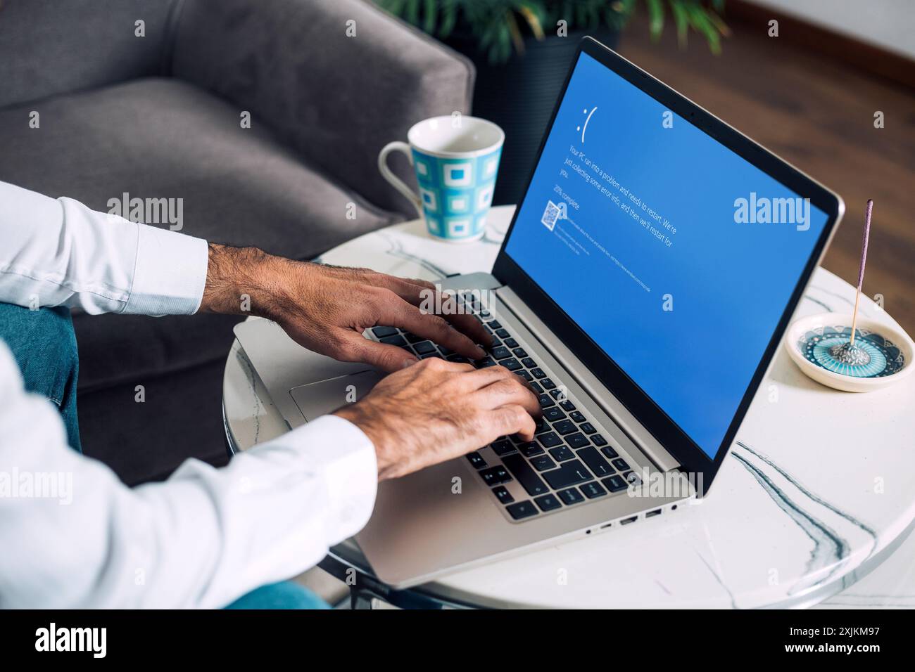 Homme avec ordinateur portable montrant l'écran bleu de la mort ou BSOD sur l'écran du moniteur. Système d'exploitation Microsoft Windows 10 défectueux. Rosario, Argentine - 19 juillet Banque D'Images