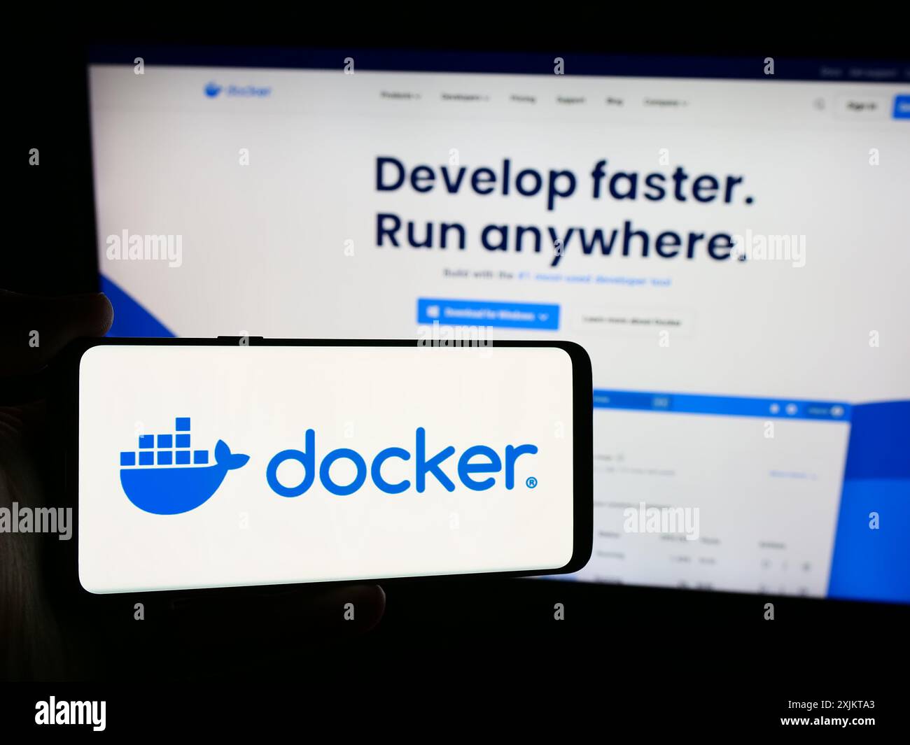 Personne tenant un smartphone avec le logo de la société américaine de logiciels de productivité Docker Inc en face du site Web. Concentrez-vous sur l'affichage du téléphone. Banque D'Images