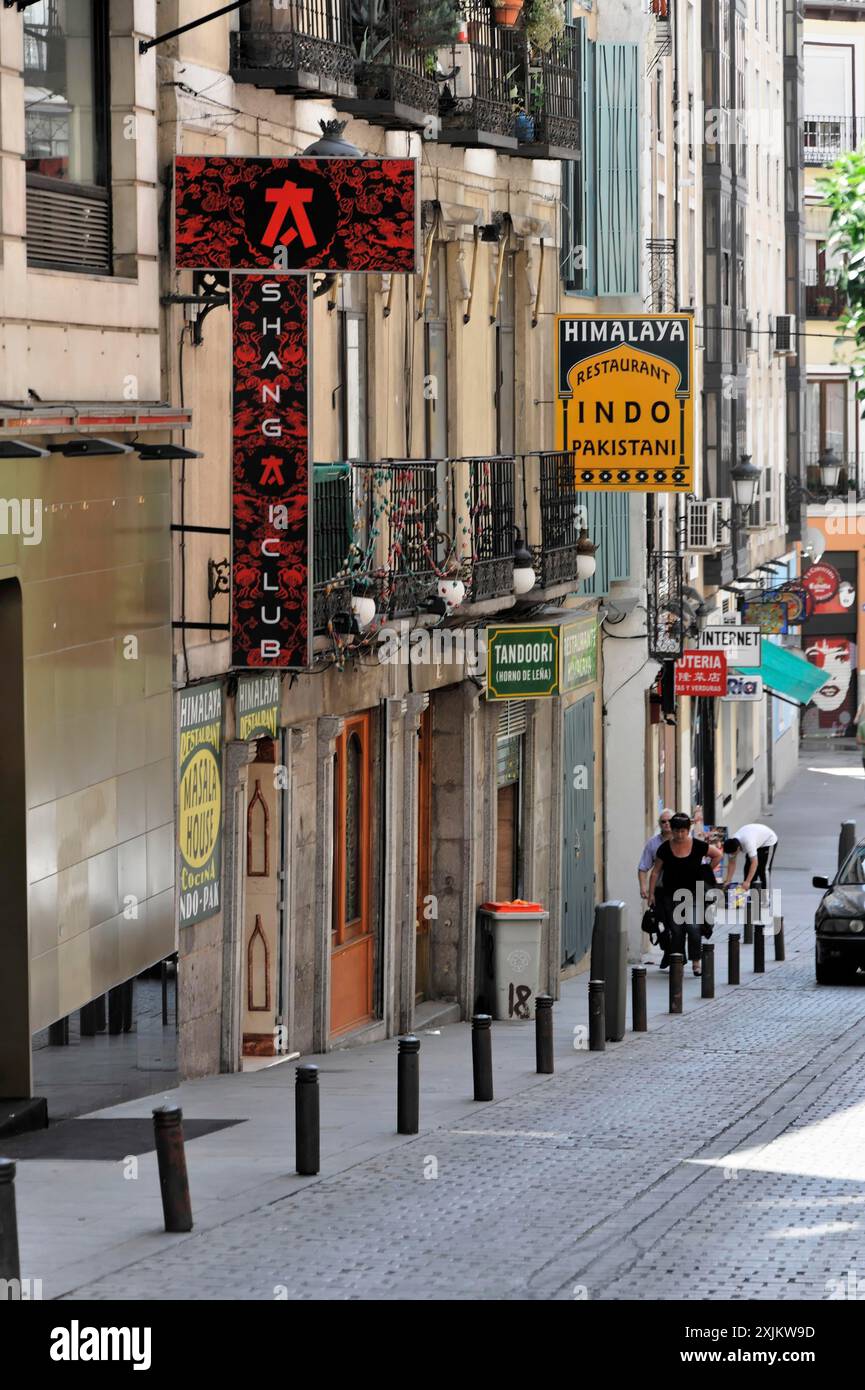 Madrid, Espagne, Europe, Une rue étroite avec divers magasins et panneaux colorés, les gens marchant le long de la rue Banque D'Images