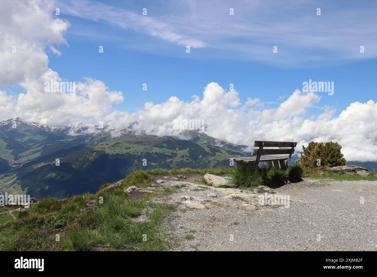 Vue d'un banc en bois dans les hautes montagnes avec une vue fantastique sur les chaînes de montagnes et le ciel bleu nuageux Banque D'Images