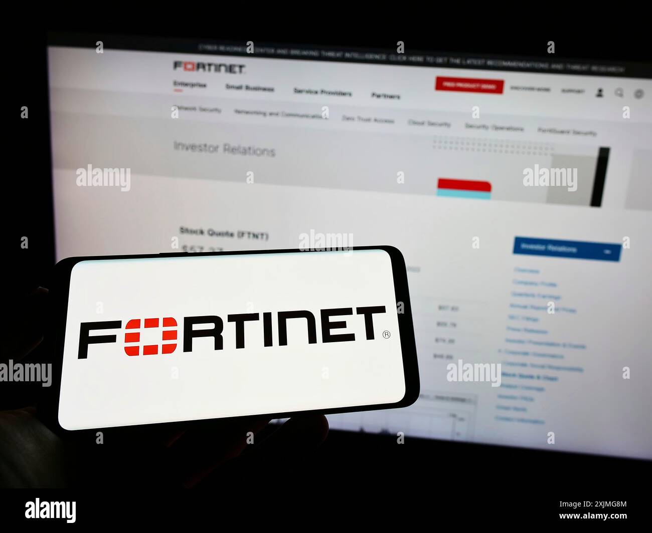 Stuttgart, Allemagne, 07-03-2022 : personne tenant un téléphone portable avec le logo de la société américaine de cybersécurité Fortinet Inc. sur l'écran devant la page Web de l'entreprise. Banque D'Images