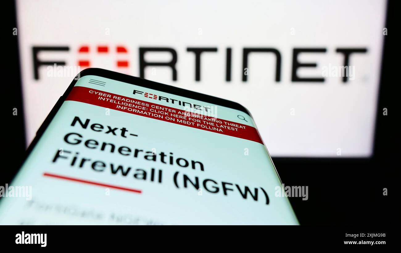 Stuttgart, Allemagne, 07-03-2022 : smartphone avec la page web de la société américaine de cybersécurité Fortinet Inc sur l'écran devant le logo de l'entreprise. Concentrez-vous sur Banque D'Images