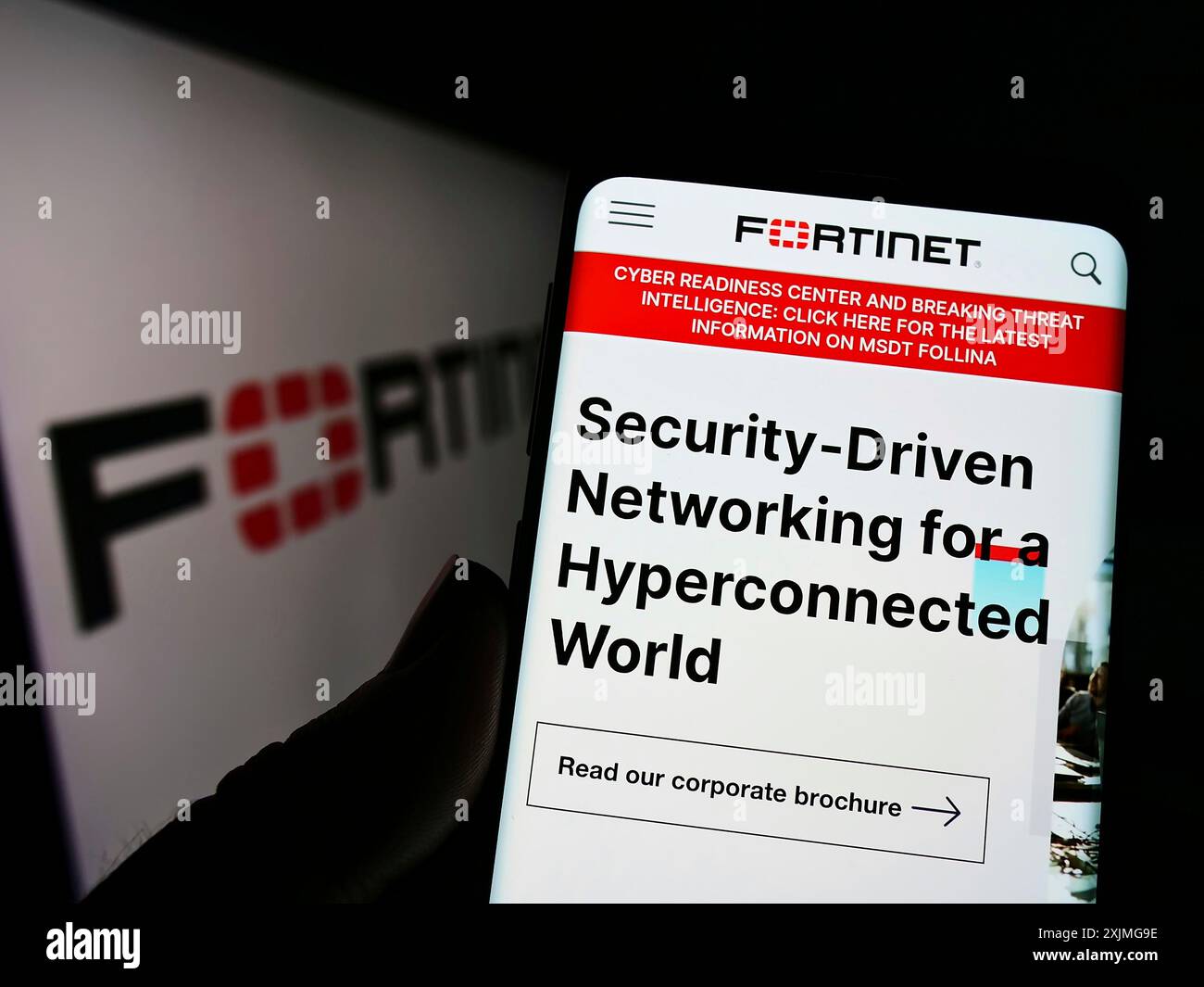Stuttgart, Allemagne, 07-03-2022 : personne tenant un téléphone portable avec le site de la société américaine de cybersécurité Fortinet Inc sur l'écran devant le logo. Concentrez-vous sur Banque D'Images