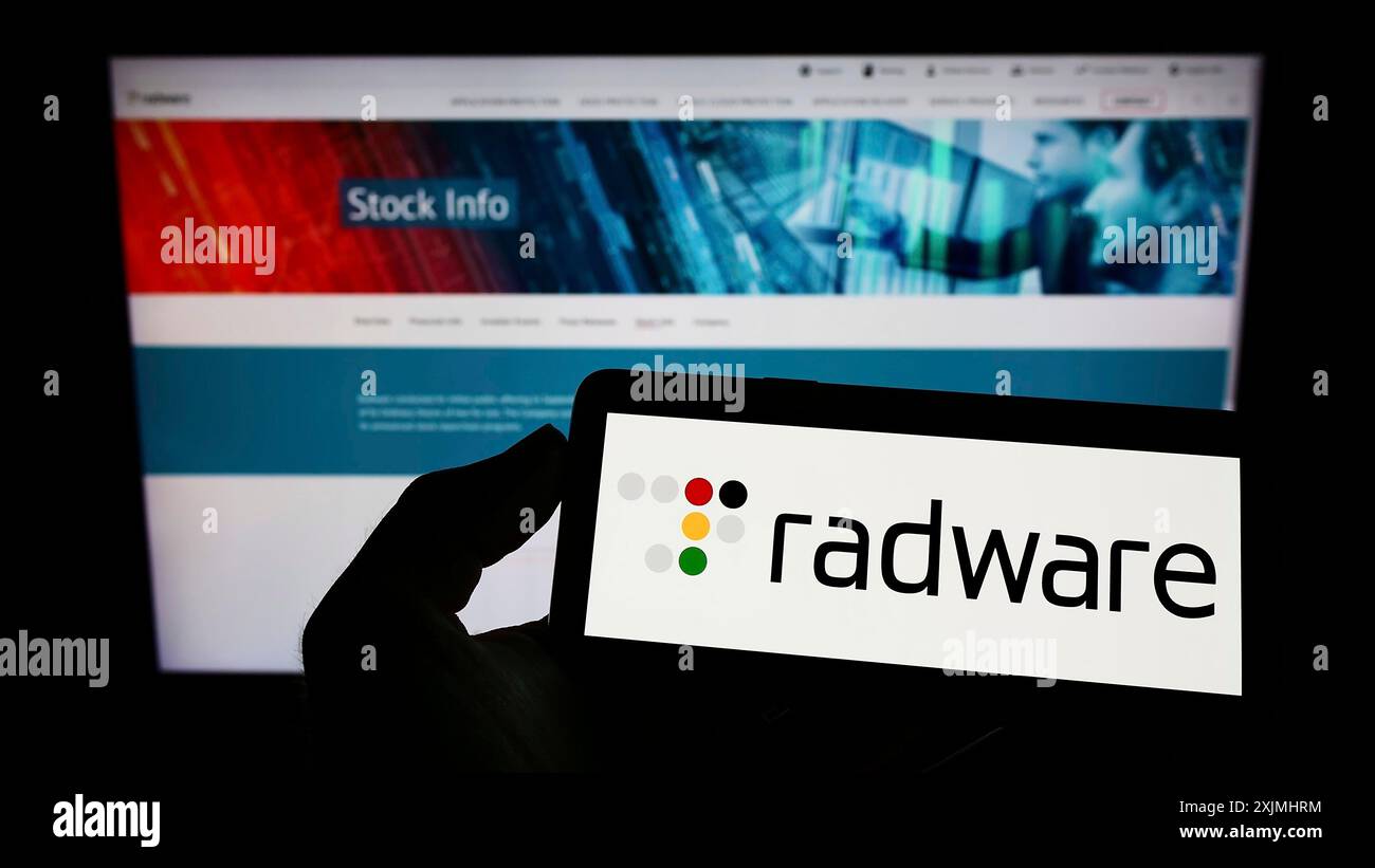 Stuttgart, Allemagne, 07-24-2022 : personne tenant un téléphone portable avec le logo de la société américaine de cybersécurité Radware Ltd sur l'écran devant l'entreprise Banque D'Images