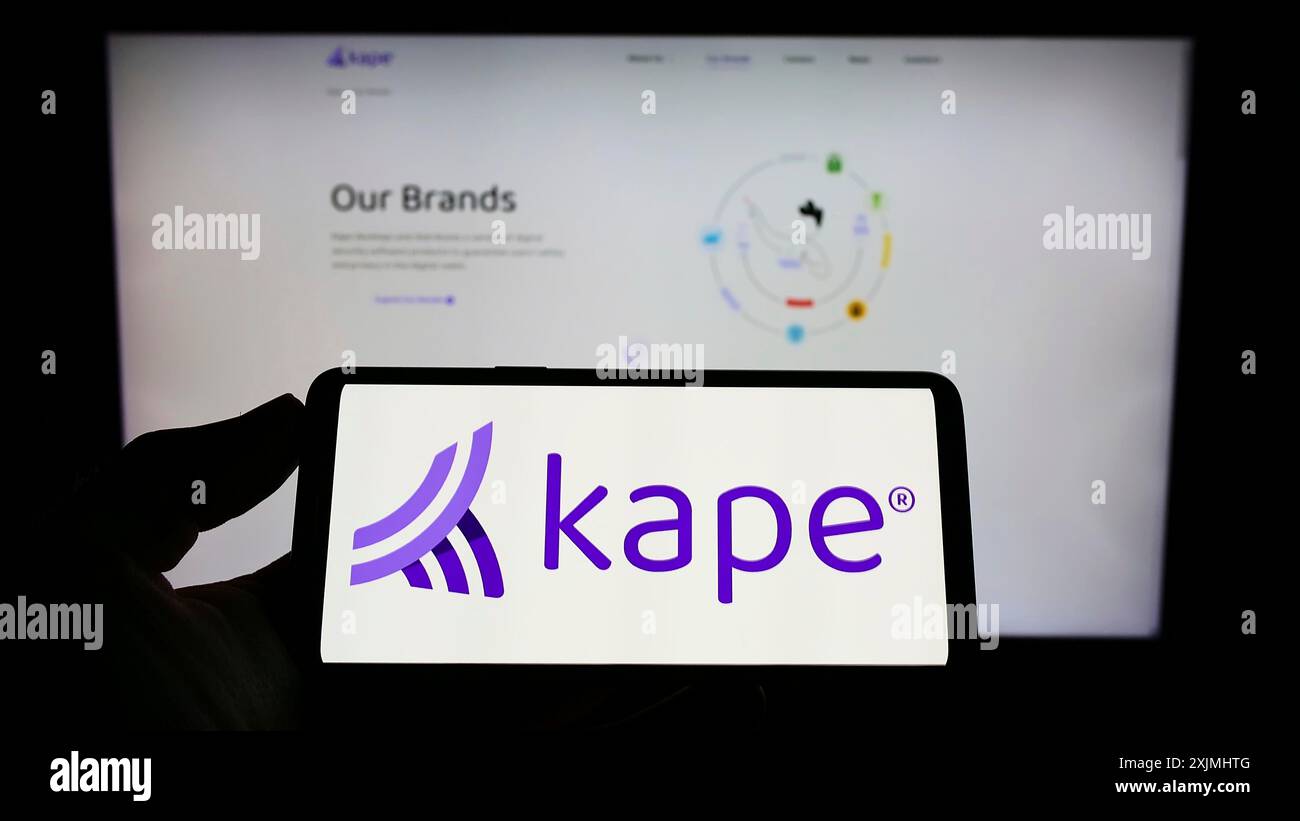 Stuttgart, Allemagne, 07-24-2022 : personne tenant un smartphone avec le logo de la société de cybersécurité Kape technologies plc sur l'écran devant le site Web. Banque D'Images