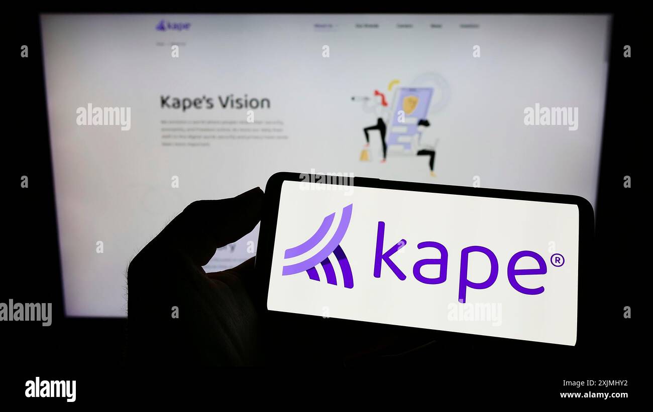 Stuttgart, Allemagne, 07-24-2022 : personne tenant un téléphone portable avec le logo de la société de cybersécurité Kape technologies plc sur l'écran devant l'entreprise Banque D'Images