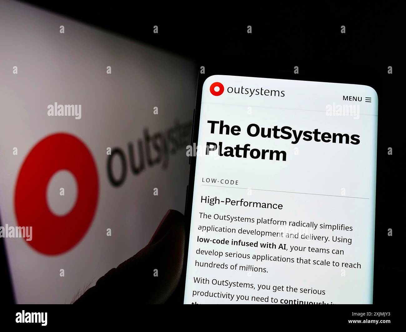 Stuttgart, Allemagne, 07-31-2022, personne tenant un téléphone portable avec la page web de la société de logiciels low-code OutSystems sur l'écran devant le logo. Concentrez-vous sur Banque D'Images