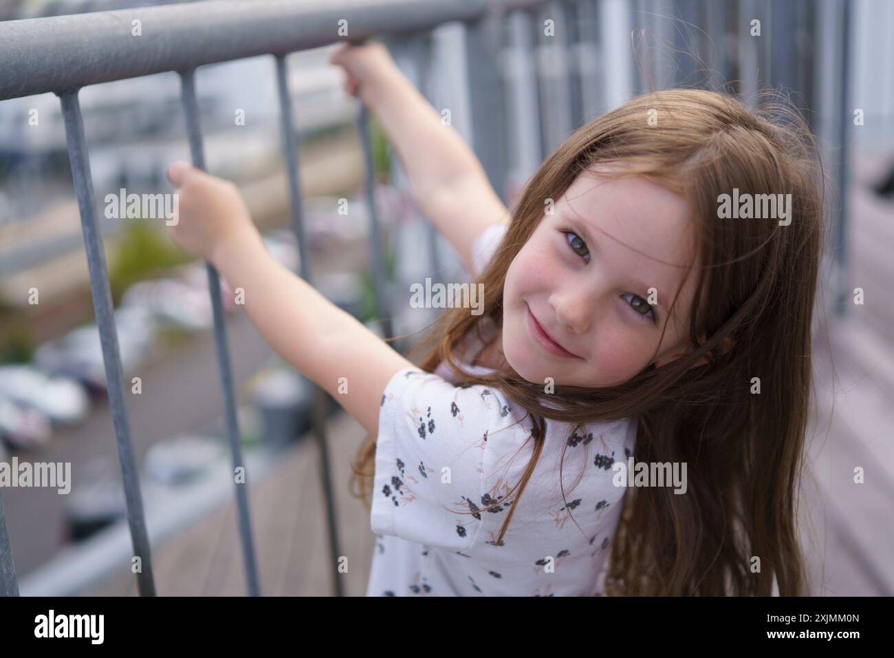 Une petite, belle écolière manquant une dent de devant accrochée à la balustrade. Concept de santé infantile Banque D'Images