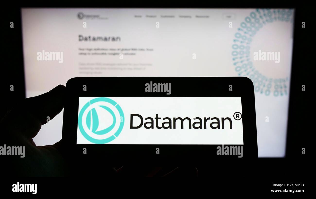Stuttgart, Allemagne, 09-25-2022, personne tenant un téléphone portable avec le logo de la société britannique de logiciels ESG Datamaran Ltd sur l'écran devant l'entreprise Banque D'Images